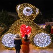 deux petites filles regardent un ours illuminé 
